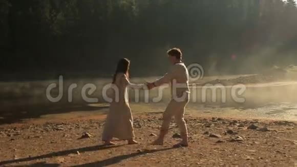 美丽的年轻夫妇相爱穿着传统的乌克兰服装在金色的塞内维尔湖边跳舞视频的预览图