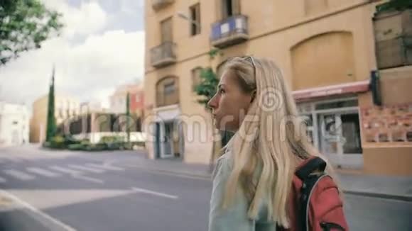 年轻女孩背着背包慢悠悠地走在大街上视频的预览图
