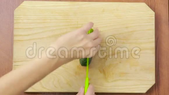 女人在厨房切黄瓜木板顶部视图视频的预览图
