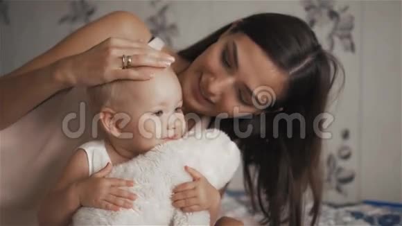 年轻漂亮的女人抱着她可爱的女儿带着玩具母亲的概念视频的预览图