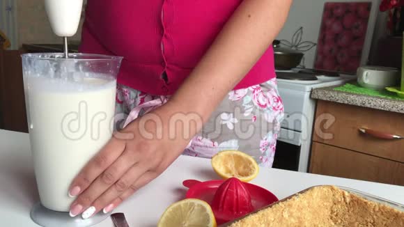一个女人用搅拌机工作美味的芝士蛋糕和蓝莓视频的预览图