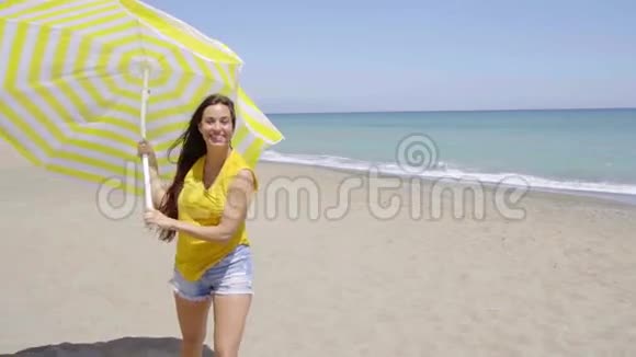 快乐的年轻女子撑着太阳伞视频的预览图