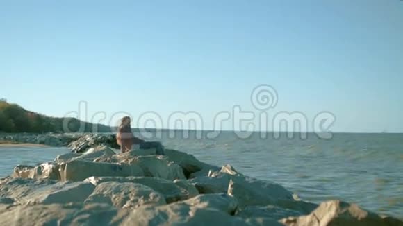 一个女孩坐在海底的岩石上视频的预览图