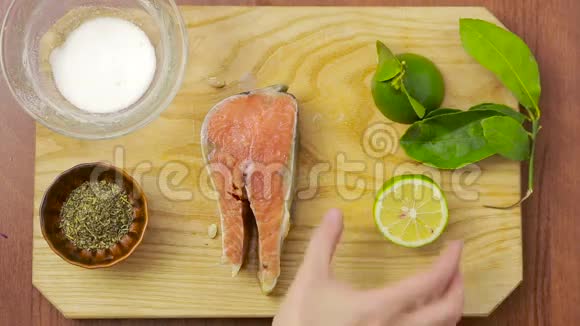 三文鱼片柠檬酸橙和香料上面的风景准备鱼的女人视频的预览图