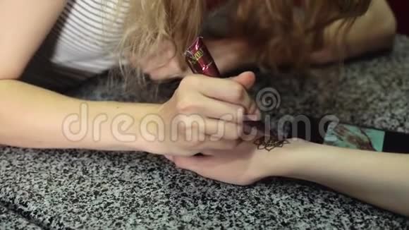 女人在一只手上做花在桌子上做指甲花视频的预览图