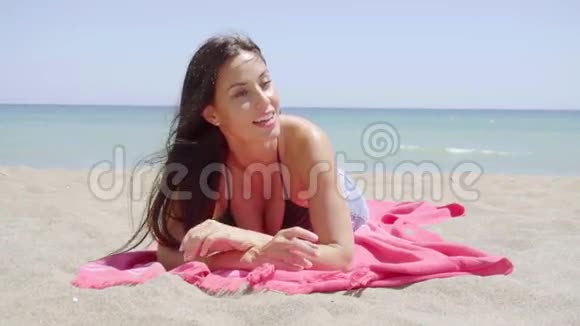 令人兴奋的年轻女子躺在沙滩上视频的预览图