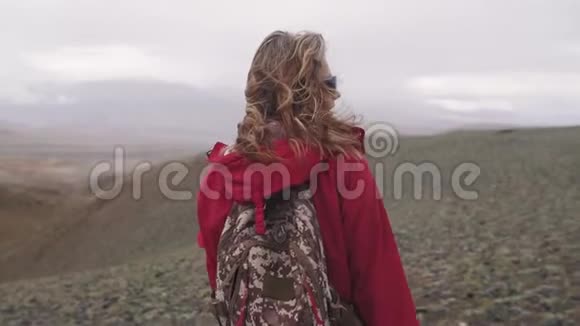 在倾盆大雨下的山上旅行者的肖像一个旅游女孩独自带着背包在高地视频的预览图