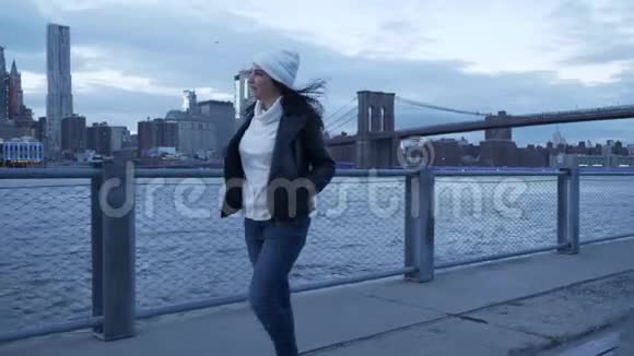 晚上年轻女子沿着曼哈顿美妙的天际线散步视频的预览图