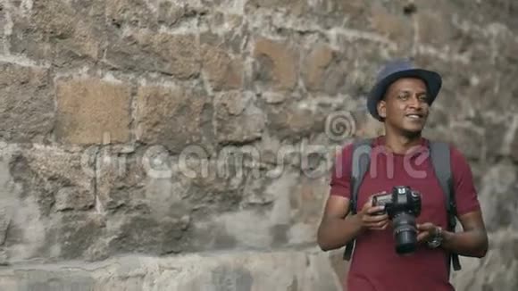 非裔美国人快乐游客在他的dslr相机上拍照站在欧洲著名建筑附近的年轻人视频的预览图