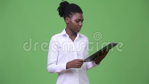 年轻漂亮的非洲女商人正在看剪贴板视频的预览图
