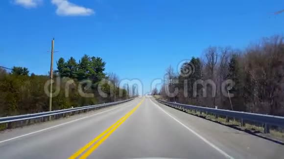 在春日期间驾驶农村司机的观点沿美丽的阳光大道视频的预览图
