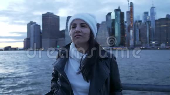 晚上年轻女子沿着曼哈顿美妙的天际线散步视频的预览图