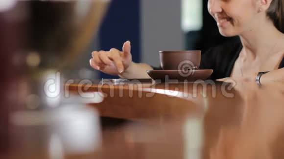 年轻的女人带着智能手机喝着咖啡微笑着中弹背景视频的预览图