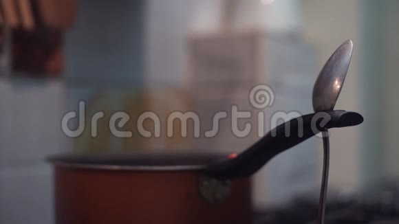 金属桌勺卡在锅柄上在厨房摆动视频的预览图