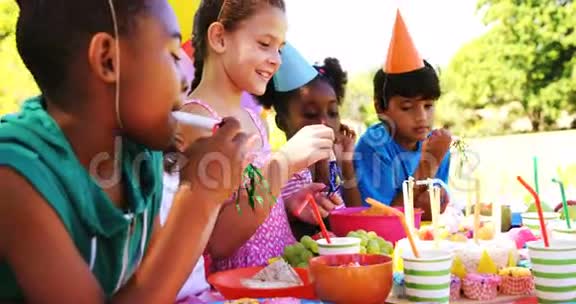 孩子们站在桌子旁摆着食物庆祝生日视频的预览图