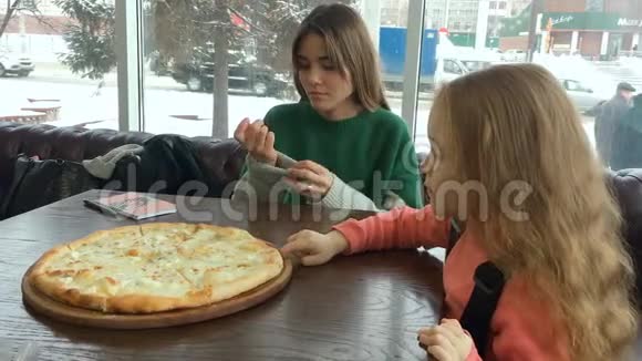 小女孩的肖像在披萨店里嚼一块披萨玛格丽塔视频的预览图