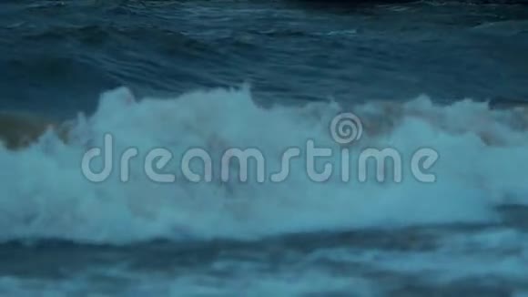 蓝色的海浪照亮了海滩上的橙色日落视频的预览图
