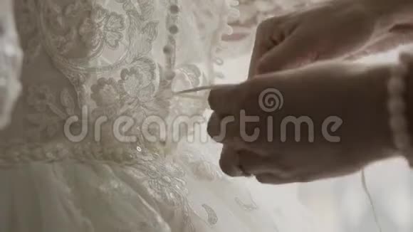 在年轻新娘的后面准备婚礼妈妈帮女儿穿婚纱视频的预览图