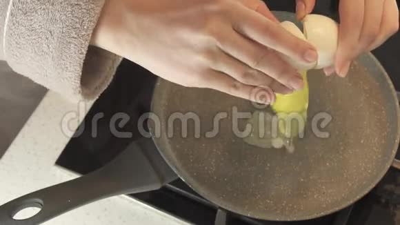 家庭主妇把生鸡蛋煎在锅里然后用烧焦的录像视频的预览图