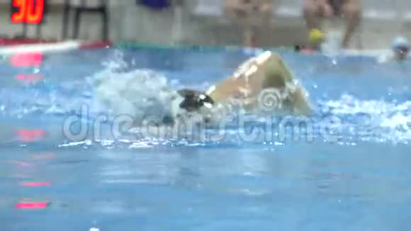 年轻人在游泳池里朝镜头游去慢镜头视频的预览图