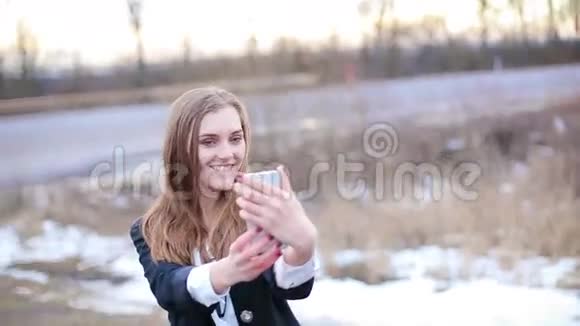 女孩用智能手机的正面摄像头做自拍视频的预览图