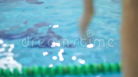 无法辨认的人在游泳池里潜水慢动作近距离射击视频的预览图