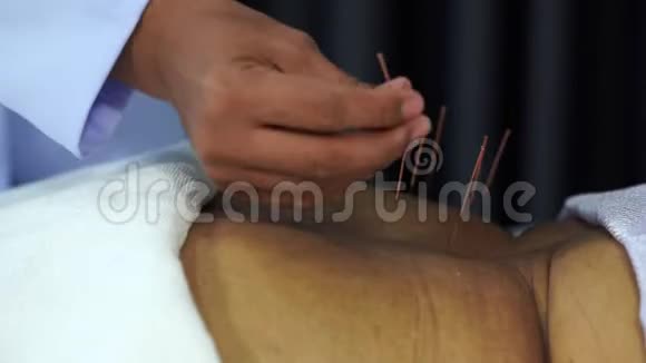针刺治疗过程中使用钢针的老年女性背部视频的预览图