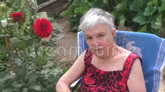 一位老年妇女坐在大自然的椅子上视频的预览图