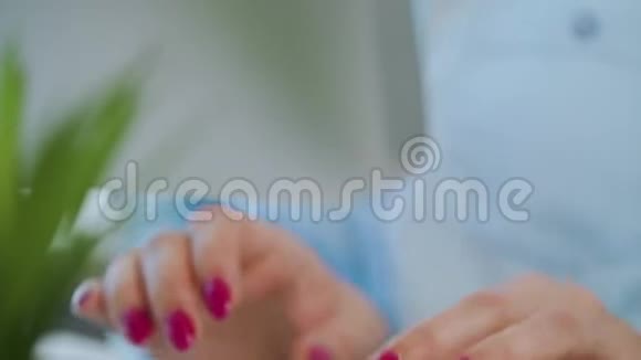 在电脑键盘上输入漂亮指甲的女性手视频的预览图