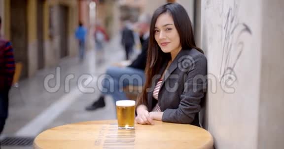 友好的年轻女子坐着喝啤酒视频的预览图