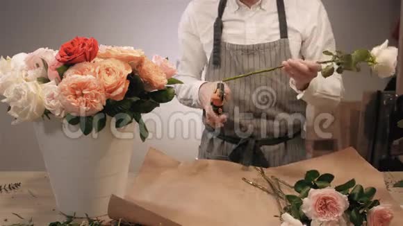 男性花店手特写切花玫瑰花为花束花卉设计工作室的男助理或业主视频的预览图