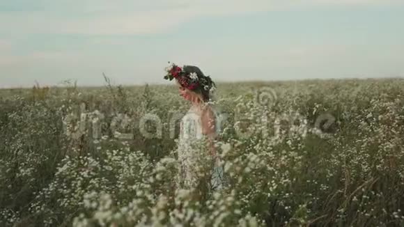 戴着花圈的美丽女孩在花丛中漫步视频的预览图