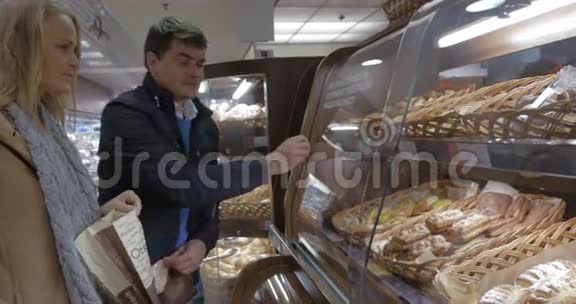 男人和女人在商店里买美味的面包视频的预览图