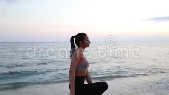 地中海海滩日落时做瑜伽的运动女孩视频的预览图
