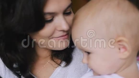 年轻快乐的母亲抱着她的新生儿接吻家里的家人美丽的微笑妈妈和快乐的宝贝在一起视频的预览图
