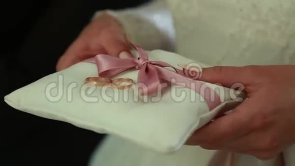 新婚夫妇的结婚戒指在丝绸枕头上视频的预览图