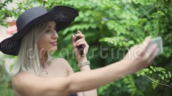 年轻时尚的漂亮女人戴帽子做自拍使用智能手机的女性视频的预览图