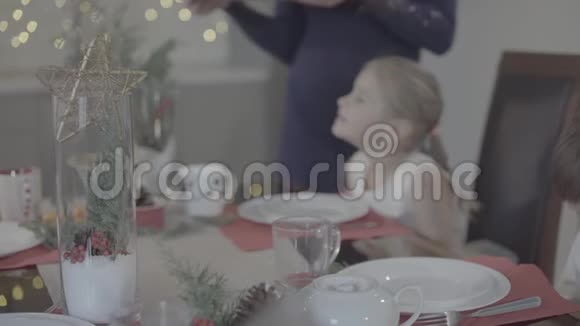 爱的母亲亲吻快乐兴奋可爱的女儿脸颊在节日的晚餐厨房圣诞装饰视频的预览图