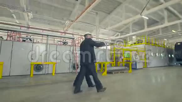商人穿过工业工厂视频的预览图