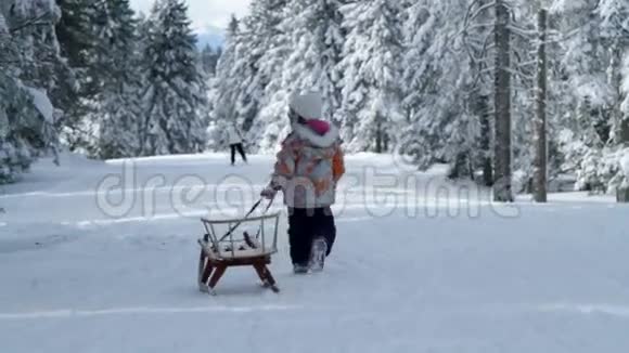 小女孩拉雪橇享受冬天的时光视频的预览图