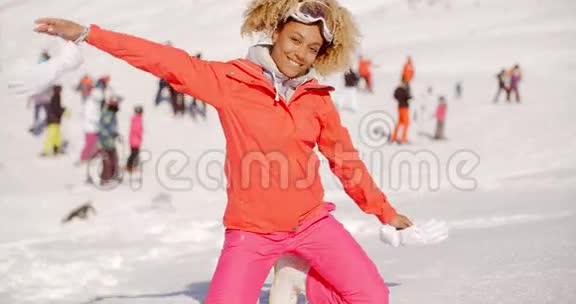 在雪地里摆姿势的嬉戏的年轻女子视频的预览图