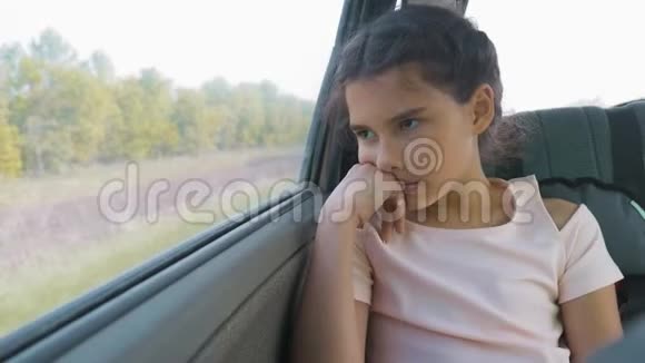 伤心的女孩无聊地坐在车后座上运动旅行小女孩在车里无聊生活方式观念视频的预览图