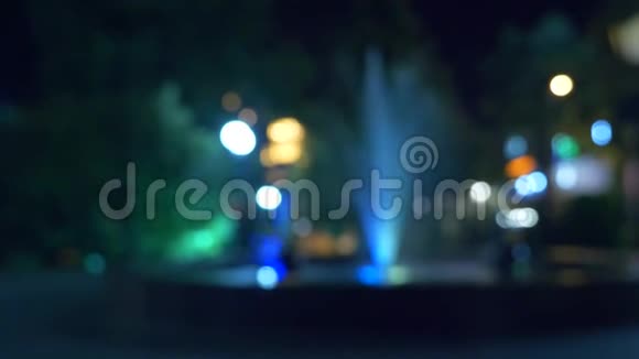 一个有彩色灯光的喷泉在晚上特写模糊4k视频的预览图