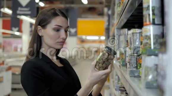 女人选择罐装橄榄在食品超市购物视频的预览图