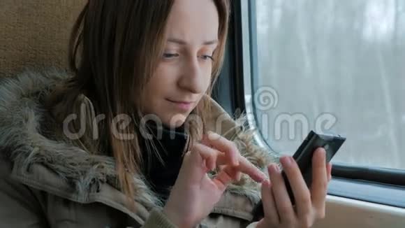 一个在火车上用智能手机旅行的女人视频的预览图