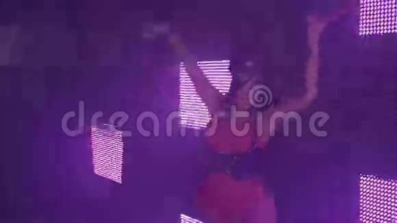 MC女孩戴着兔子面具红色紧身衣在夜总会的屏幕上跳舞业绩视频的预览图
