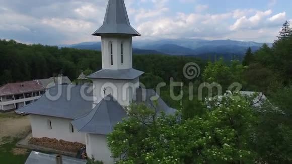基督教教堂周围有绿色森林山脉鸟瞰视频的预览图