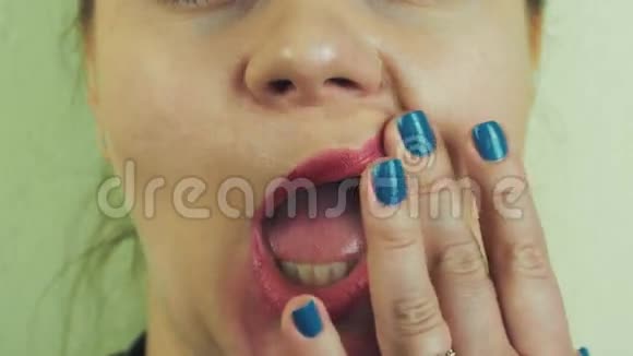 女人在镜头前用嘴抹红油微笑牙齿脸面视频的预览图