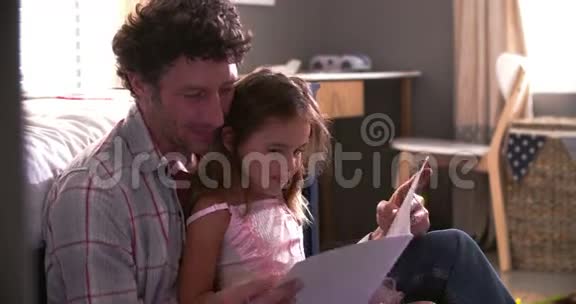 父亲和女儿在儿童卧室读书视频的预览图