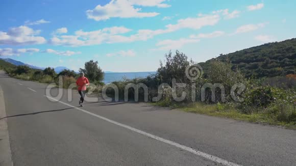 户外健身妇女在开阔的乡间道路上奔跑的镜头视频的预览图